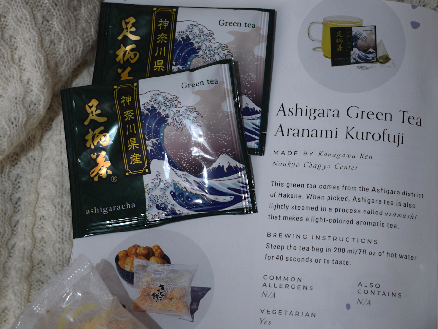 Two packets of green tea next to a leaflet describing them