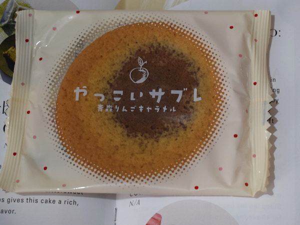 A wrapped apple caramel cookie next to a leaflet describing it