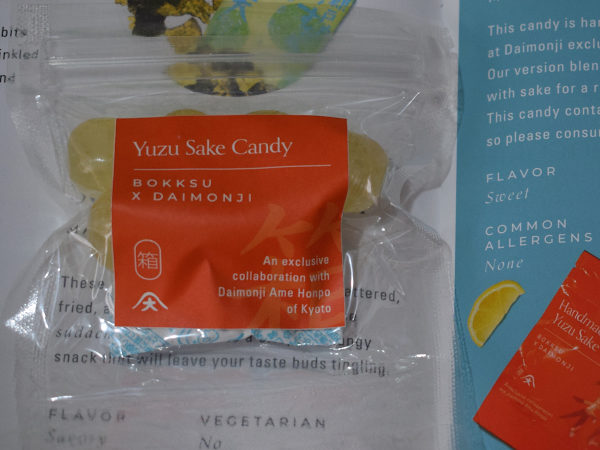 A packet of yuzu and sake hard candy next to a leaflet describing it