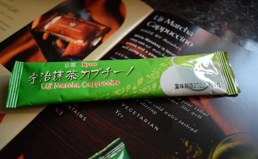 a single sachet of uji matcha cappuccino next to a leaflet describing them