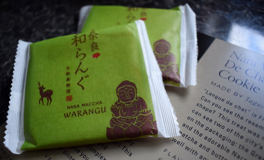 two matcha sandwich cookies next to a leaflet describing them