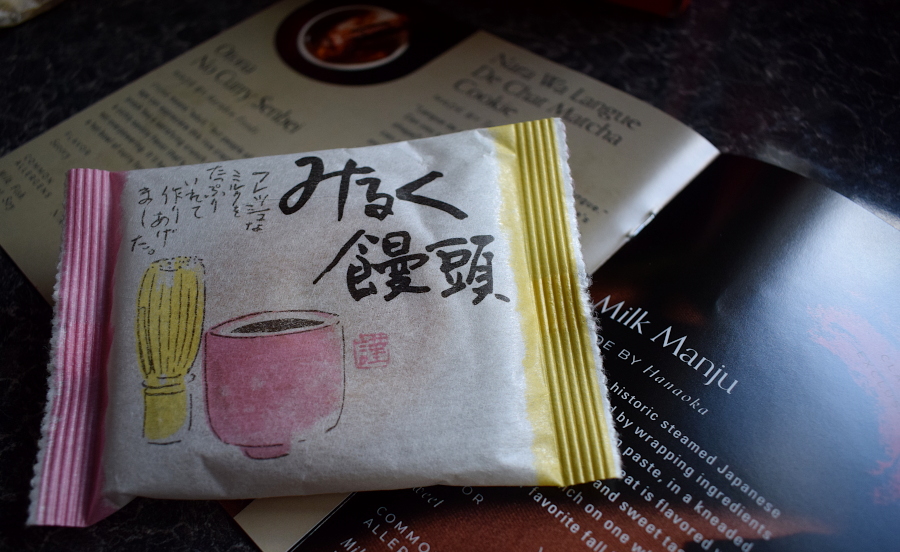 a milk manju, a sweet pastry, next to a leaflet describing them