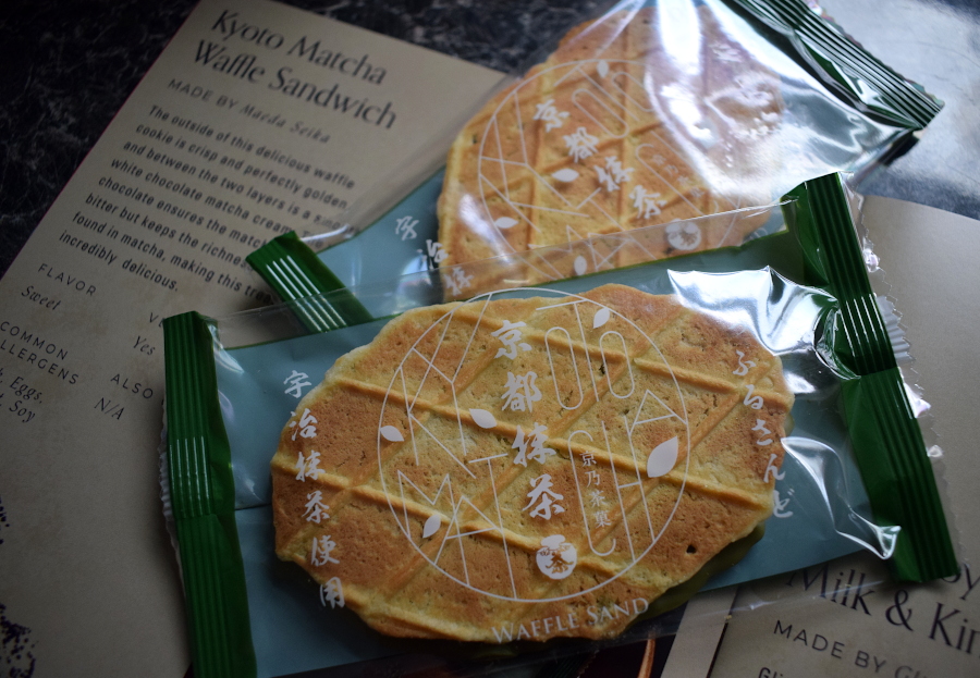 two matcha white chocolate sandwich cookies next to a leaflet describing them