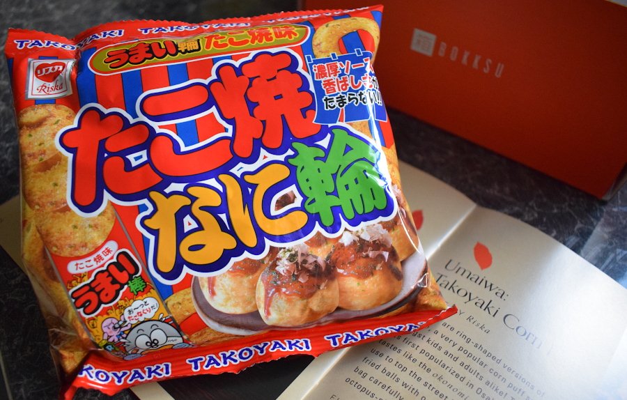 a packet of takoyaki flavoured snacks next to a leaflet describing them