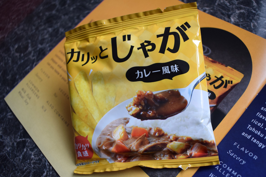 a packet of curry flavoured rice crackers next to a leaflet describing them