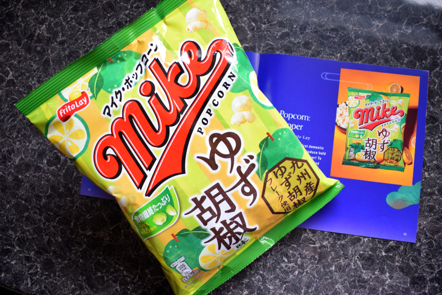 a single large packet of yuzu pepper flavoured popcorn next to a leaflet describing them